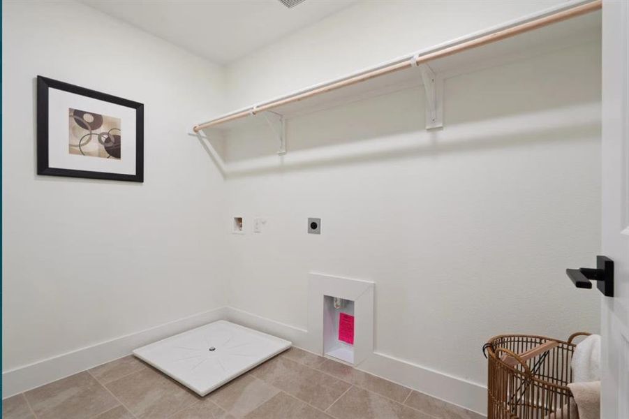 Washroom with hookup for an electric dryer, hookup for a washing machine, baseboards, and light tile patterned floors