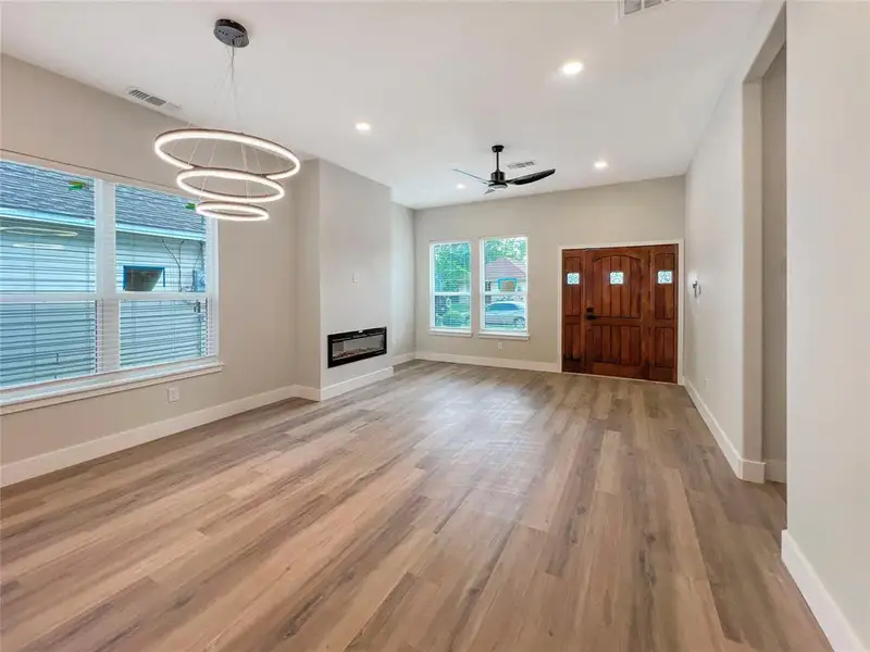 Unfurnished living room featuring light wood finished floors, baseboards, visible vents, and recessed lighting