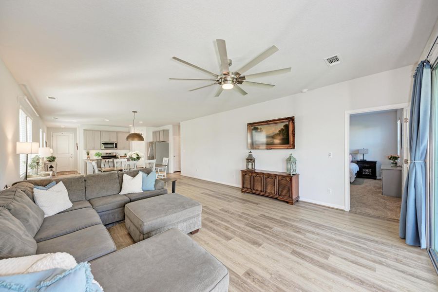 Living area with light wood-type flooring, ceiling fan, and recessed lighting