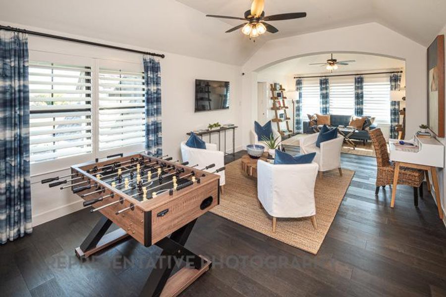 Rec room with ceiling fan, vaulted ceiling, arched walkways, and dark wood finished floors Rec room with ceiling fan, vaulted ceiling, arched walkways, and dark wood finished floors