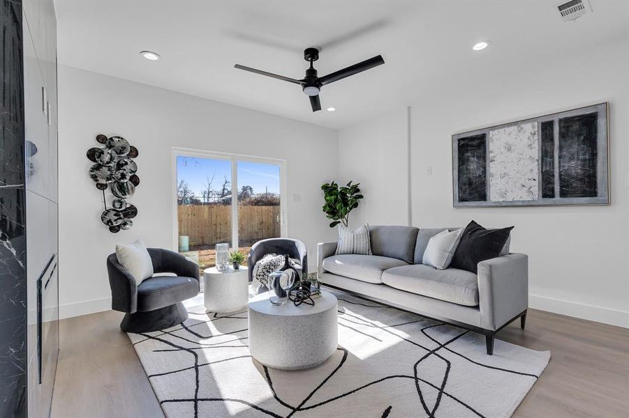 Living room with hardwood / wood-style flooring and ceiling fan