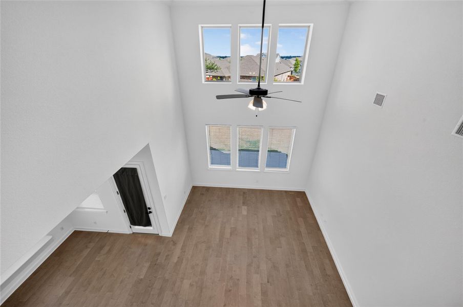 Double-height ceilings and tall windows illuminate the open-concept living area with natural light. Double-height ceilings and tall windows illuminate the open-concept living area with natural light.