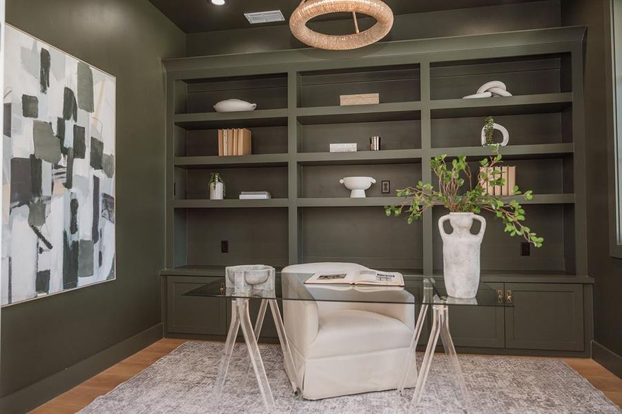 Home office featuring light wood finished floors and built in shelves Home office featuring light wood finished floors and built in shelves