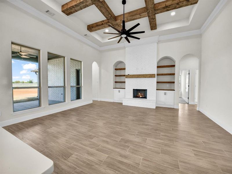Unfurnished living room with arched walkways, baseboards, wood finish floors, and a ceiling fan Unfurnished living room with arched walkways, baseboards, wood finish floors, and a ceiling fan