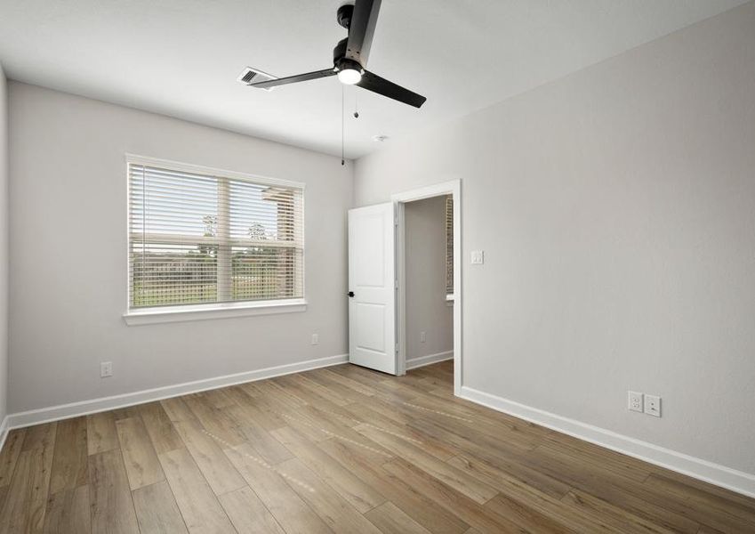 The master bedroom has plank flooring and a ceiling fan.