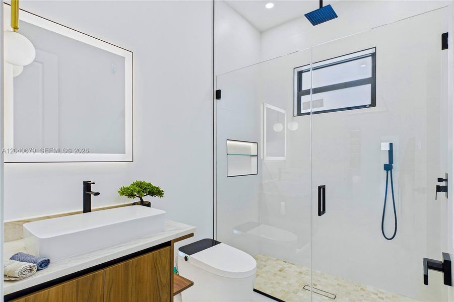 Stylish hallway bathroom features modern finishes, a sleek vanity, and convenient access for guests and secondary bedrooms