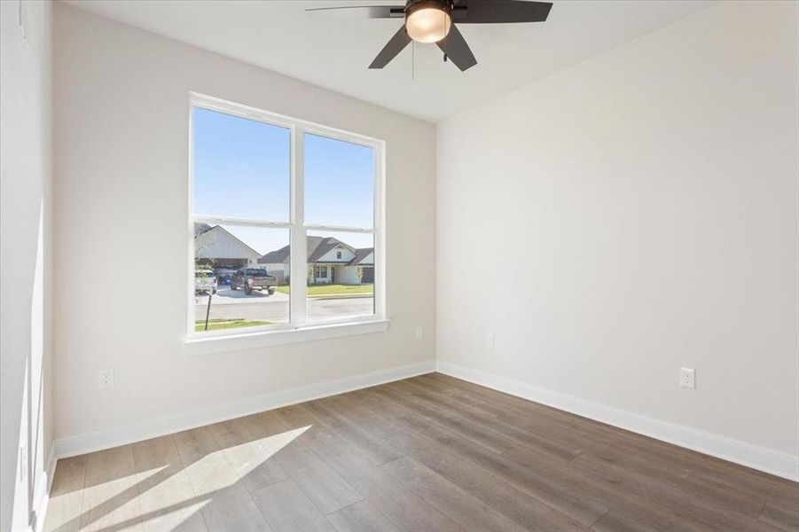 Spare room featuring wood finished floors and a ceiling fan Spare room featuring wood finished floors and a ceiling fan