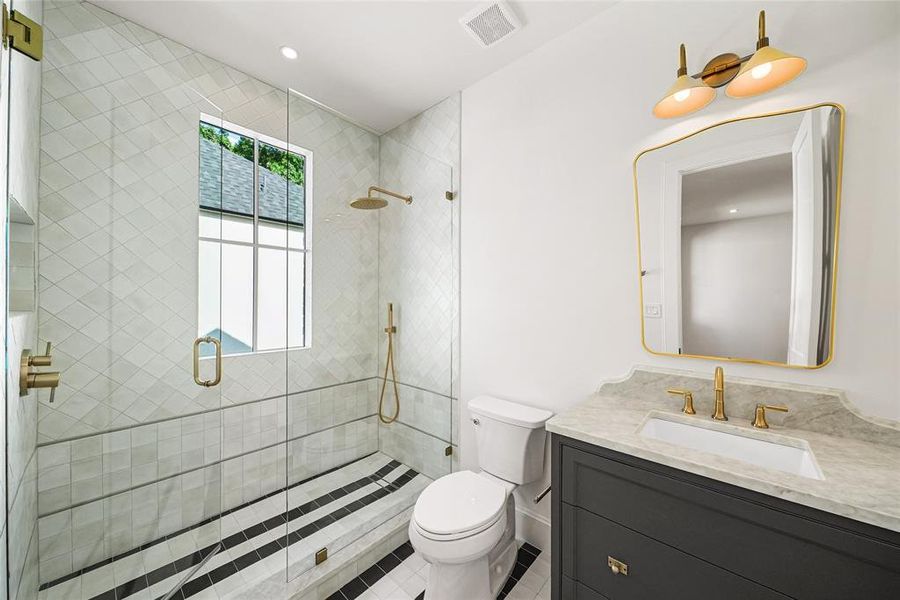Bathroom featuring a glass-enclosed shower with geometric tile patterns and a built-in bench