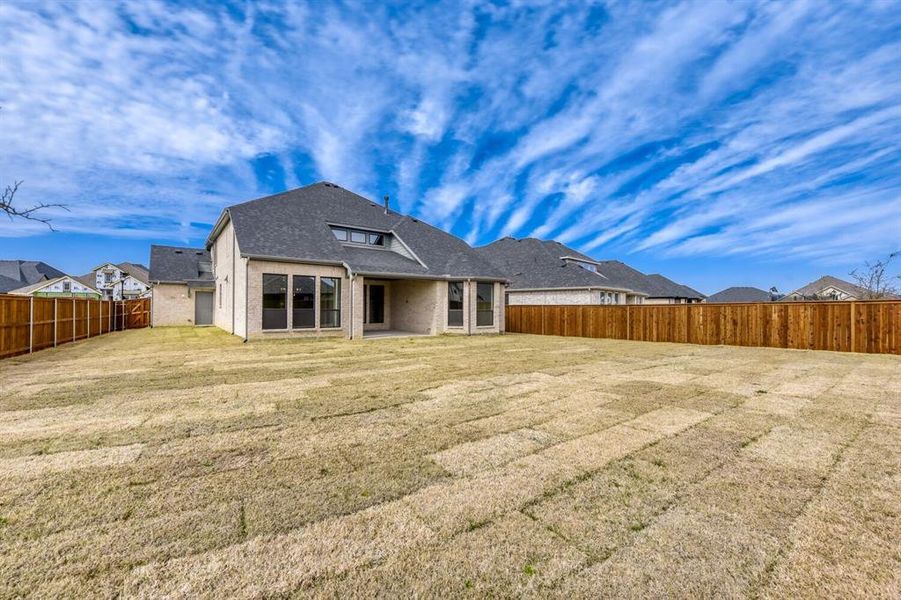 Back of house with a patio, brick siding, a shingled roof, and a fenced backyard