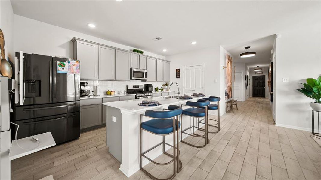 View of kitchen with new appliances, walk in pantry, and leading to the hallway with bedrooms 2-4.