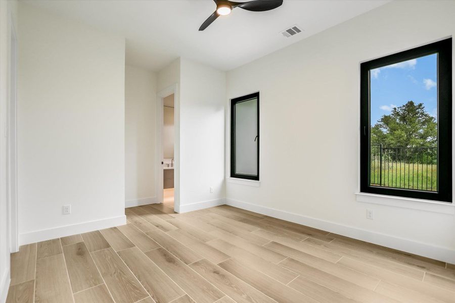 Spacious room featuring light wood-finish flooring and bright white walls