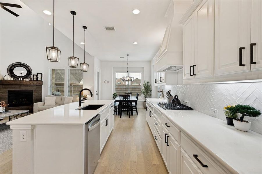 Spacious kitchen featuring an expansive island with an undermount sink, stainless steel dishwasher, and quartz countertops