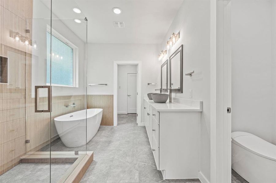 Full bathroom featuring toilet, vanity, tile walls, independent shower and bath, and tile patterned floors