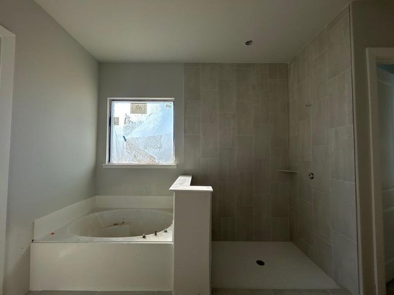 Full bathroom featuring a bath, a tile shower, and tile patterned floors