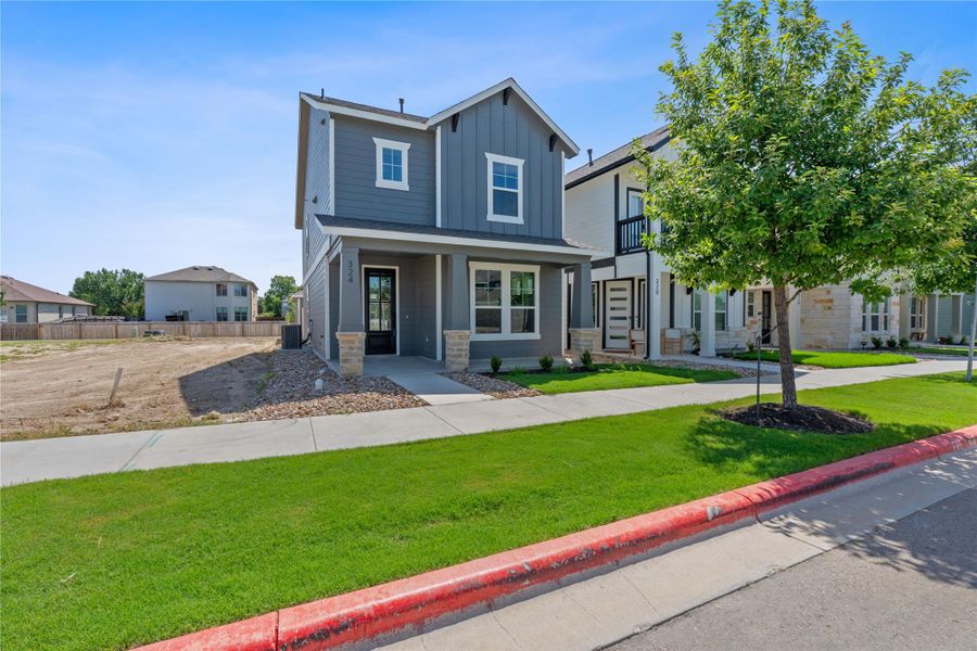 View of front of house with board and batten siding, stone siding, and covered porch