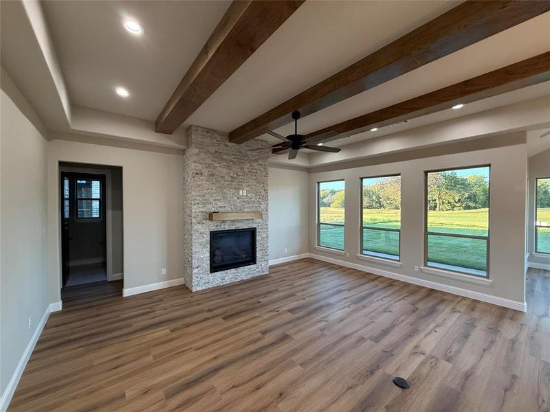 Unfurnished living room featuring beam ceiling, healthy amount of natural light, light wood-style flooring, a ceiling fan, and recessed lighting Unfurnished living room featuring beam ceiling, healthy amount of natural light, light wood-style flooring, a ceiling fan, and recessed lighting