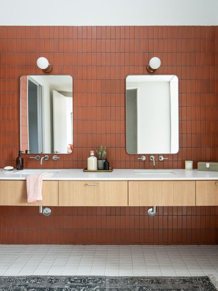 Bathroom featuring vanity, tile walls, light tile patterned floors, and tasteful backsplash