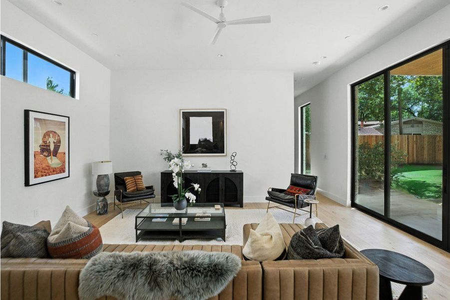 Living area with healthy amount of natural light, light wood finished floors, and ceiling fan Living area with healthy amount of natural light, light wood finished floors, and ceiling fan