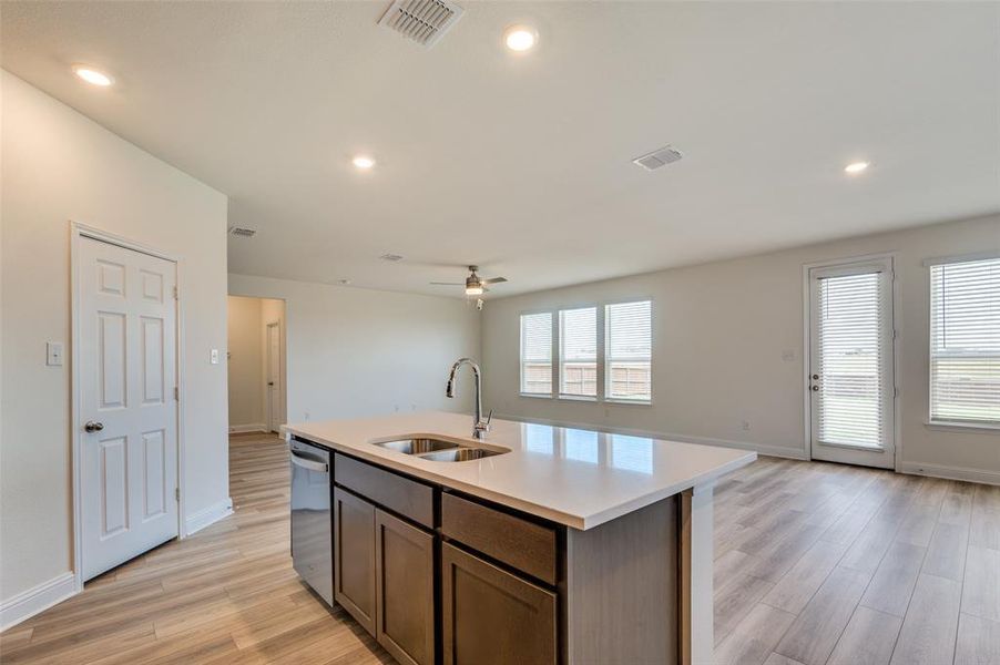 Kitchen with light wood finished floors, open floor plan, light countertops, ceiling fan, and recessed lighting