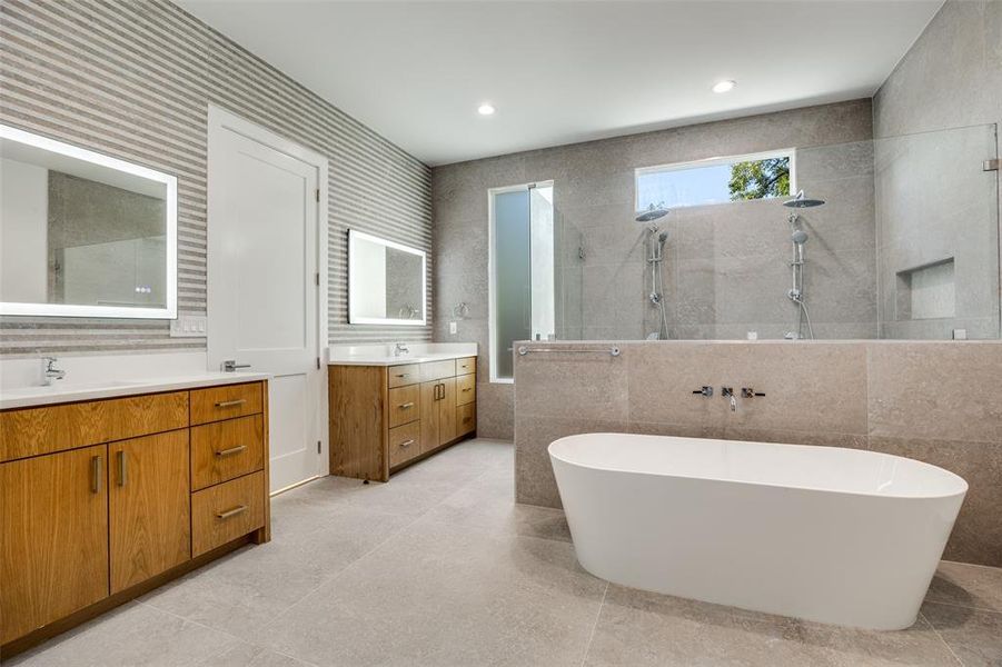 Bathroom with two vanities, tile walls, walk in shower, a soaking tub, and recessed lighting Bathroom with two vanities, tile walls, walk in shower, a soaking tub, and recessed lighting