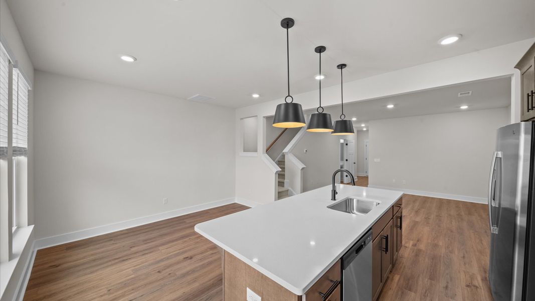 Highly skilled kitchen design includes a 9-foot island, quartz countertops, and stylish pendant fixtures Highly skilled kitchen design includes a 9-foot island, quartz countertops, and stylish pendant fixtures
