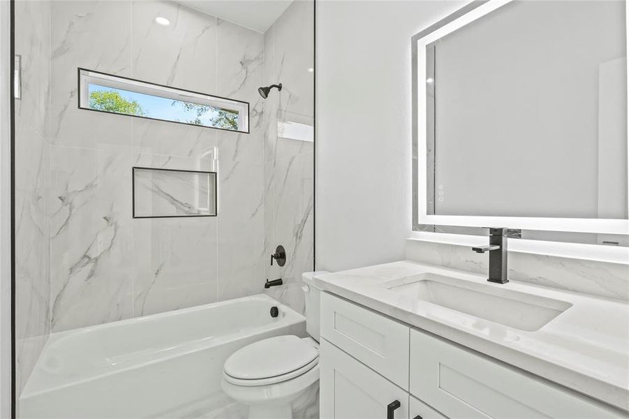 Full bath with a combined bath / shower with marble appearance and vanity