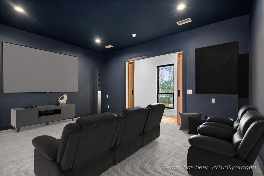 Cinema room featuring light colored carpet