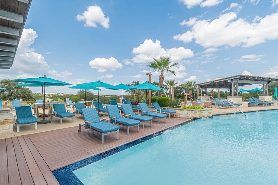 An inviting resort-style pool with a spacious sundeck awaits, complete with comfortable lounge seating and vibrant umbrellas. An inviting resort-style pool with a spacious sundeck awaits, complete with comfortable lounge seating and vibrant umbrellas.