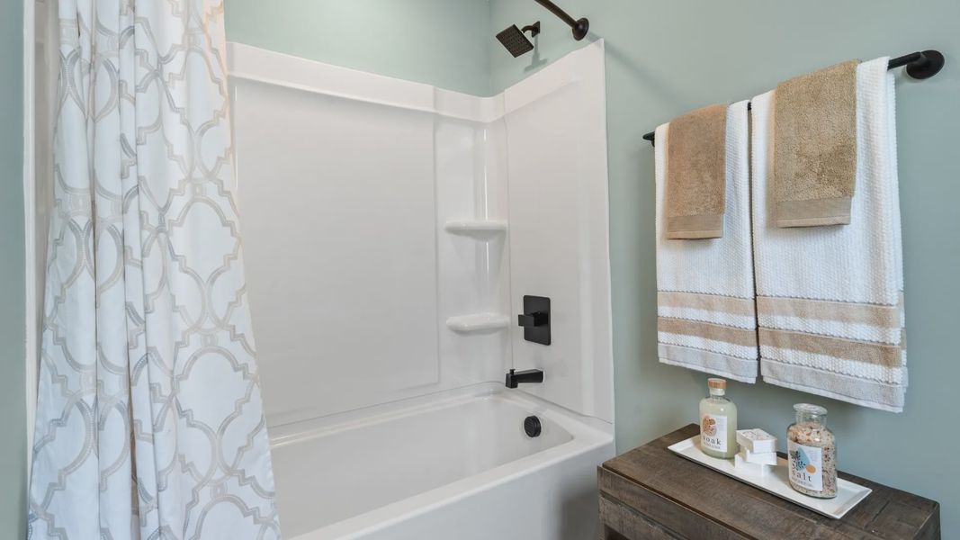 Classic tub and shower combination with refined tile surround in this secondary bathroom at Barton Hollow
