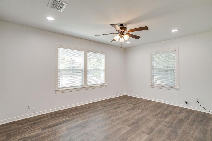 Spare room with healthy amount of natural light, dark wood-style floors, recessed lighting, and ceiling fan