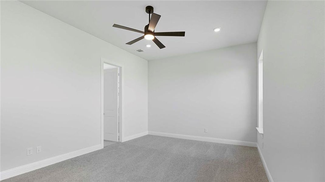 Spacious room featuring light gray carpeting, crisp white walls, a modern ceiling fan with integrated lighting, recessed ceiling lights, and a white trim window