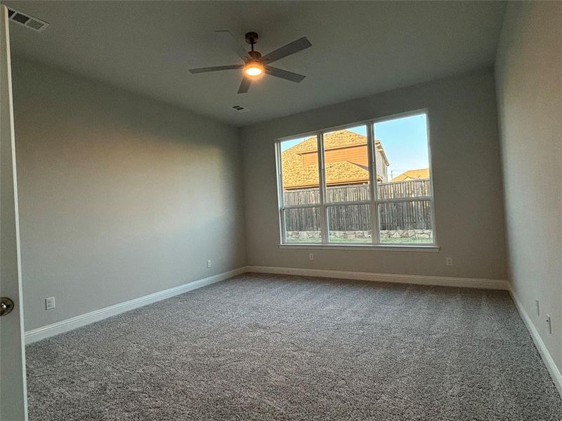 Carpeted spare room featuring ceiling fan