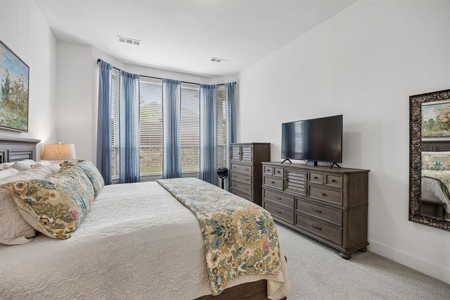 Bay window with sheer blue drapes and horizontal blinds