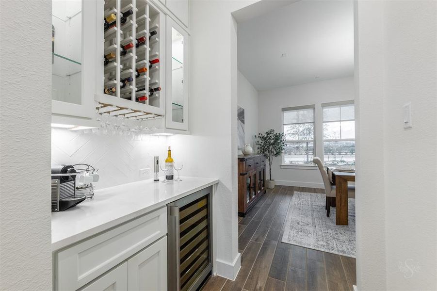 The Butlers Pantry features wine storage, wine refrigerator, in-cabinet lighting serving space as well as storage.