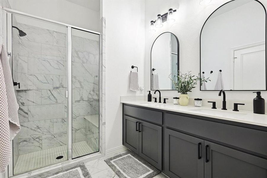 Bathroom with dual vanity, an enclosed shower, and tile patterned floors