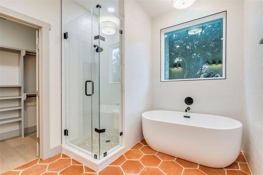 Full bathroom with a shower stall, a soaking tub, tile patterned flooring, and a spacious closet
