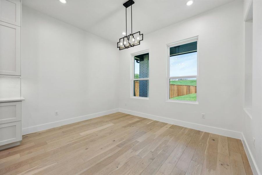 Unfurnished dining area with light hardwood / wood-style flooring and a chandelier