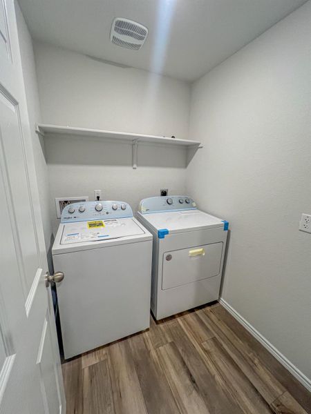 Laundry room with light wood-style flooring and washer and dryer