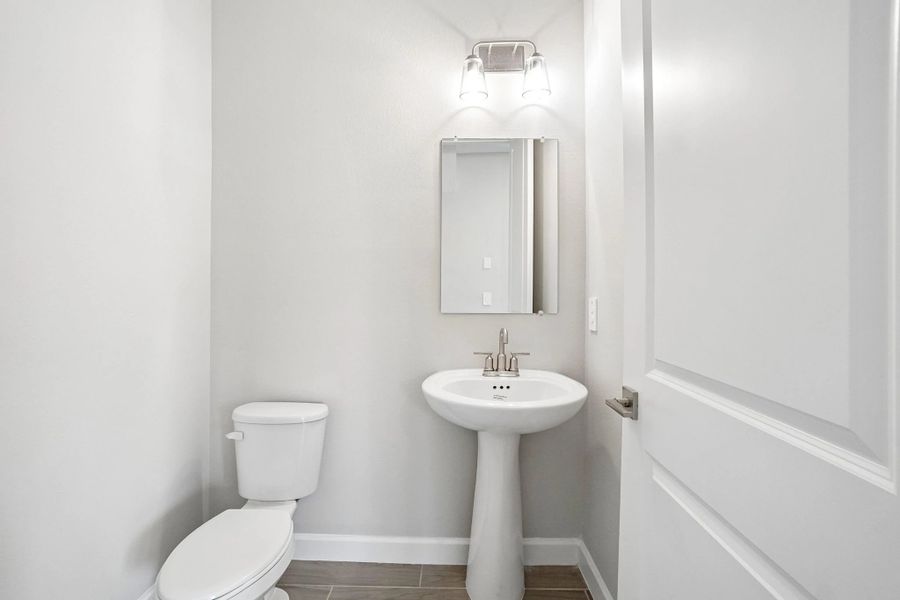 Off the kitchen near the garage you will find the half bathroom