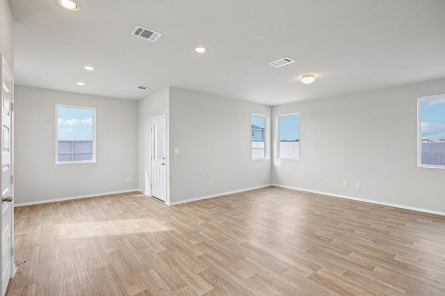 Image of a living room with light grey walls, light brown wood-look flooring, windows and white trim Image of a living room with light grey walls, light brown wood-look flooring, windows and white trim