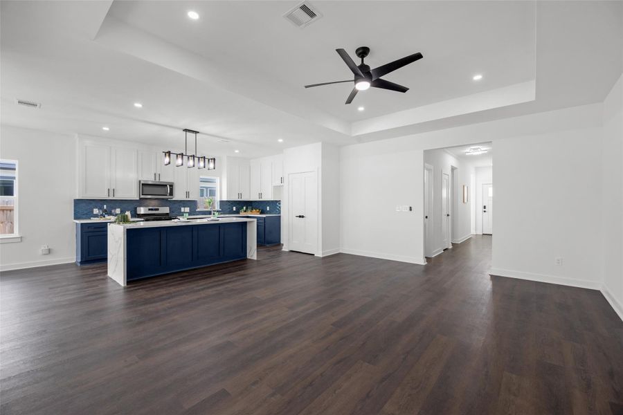 Family room with dark hardwood floors and a modern ceiling fan.