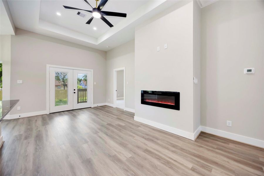 Spacious living room with sophisticated fireplace;creating a welcoming and cozy ambience. Luxury vinyl flooring, ceiling fan, designer fixture, and windows allowing natural light to enter the home! Spacious living room with sophisticated fireplace;creating a welcoming and cozy ambience. Luxury vinyl flooring, ceiling fan, designer fixture, and windows allowing natural light to enter the home!