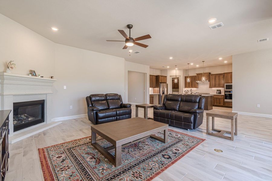 Living room with light wood finished floors, baseboards, and visible vents