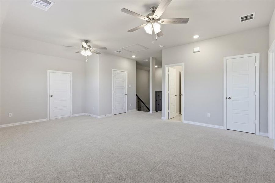 Spacious carpeted room featuring multiple ceiling fans with integrated lighting, recessed lighting, and white paneled doors