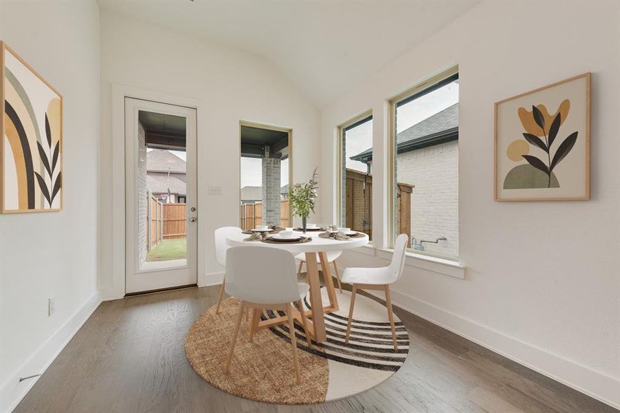 Dining room featuring plenty of natural light, wood finished floors, and lofted ceiling