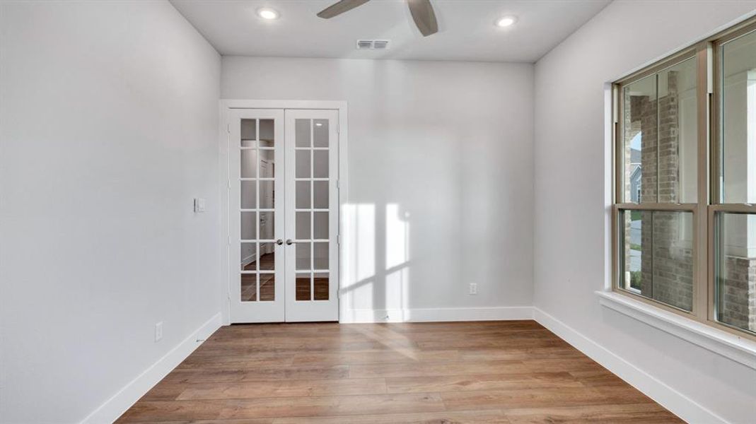 Unfurnished room with french doors, light hardwood / wood-style floors, and ceiling fan