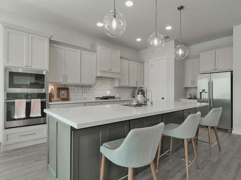 Kitchen featuring tasteful backsplash, appliances with stainless steel finishes, light wood finished floors, a center island with sink, and recessed lighting Kitchen featuring tasteful backsplash, appliances with stainless steel finishes, light wood finished floors, a center island with sink, and recessed lighting