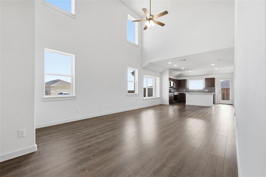Unfurnished living room featuring dark wood-type flooring and ceiling fan Unfurnished living room featuring dark wood-type flooring and ceiling fan
