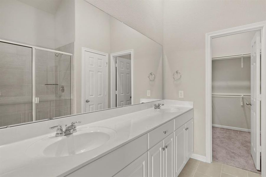 The en-suite bathroom offers a spa-like atmosphere with its elegant design, high end finishes, and tasteful lighting, creating a retreat within your own home.