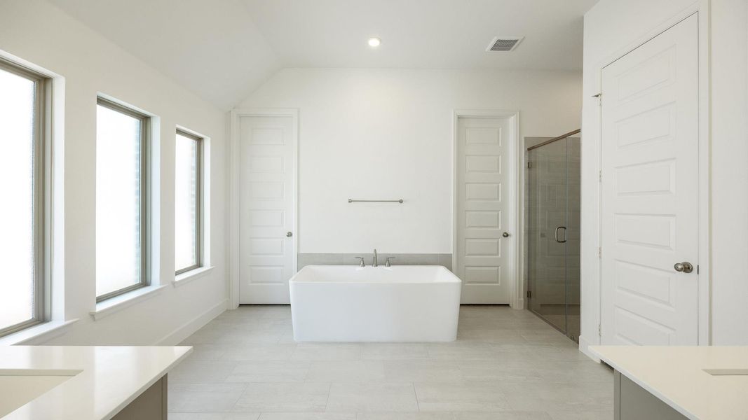Bathroom with vanity, a freestanding tub, a shower stall, light tile patterned floors, and recessed lighting